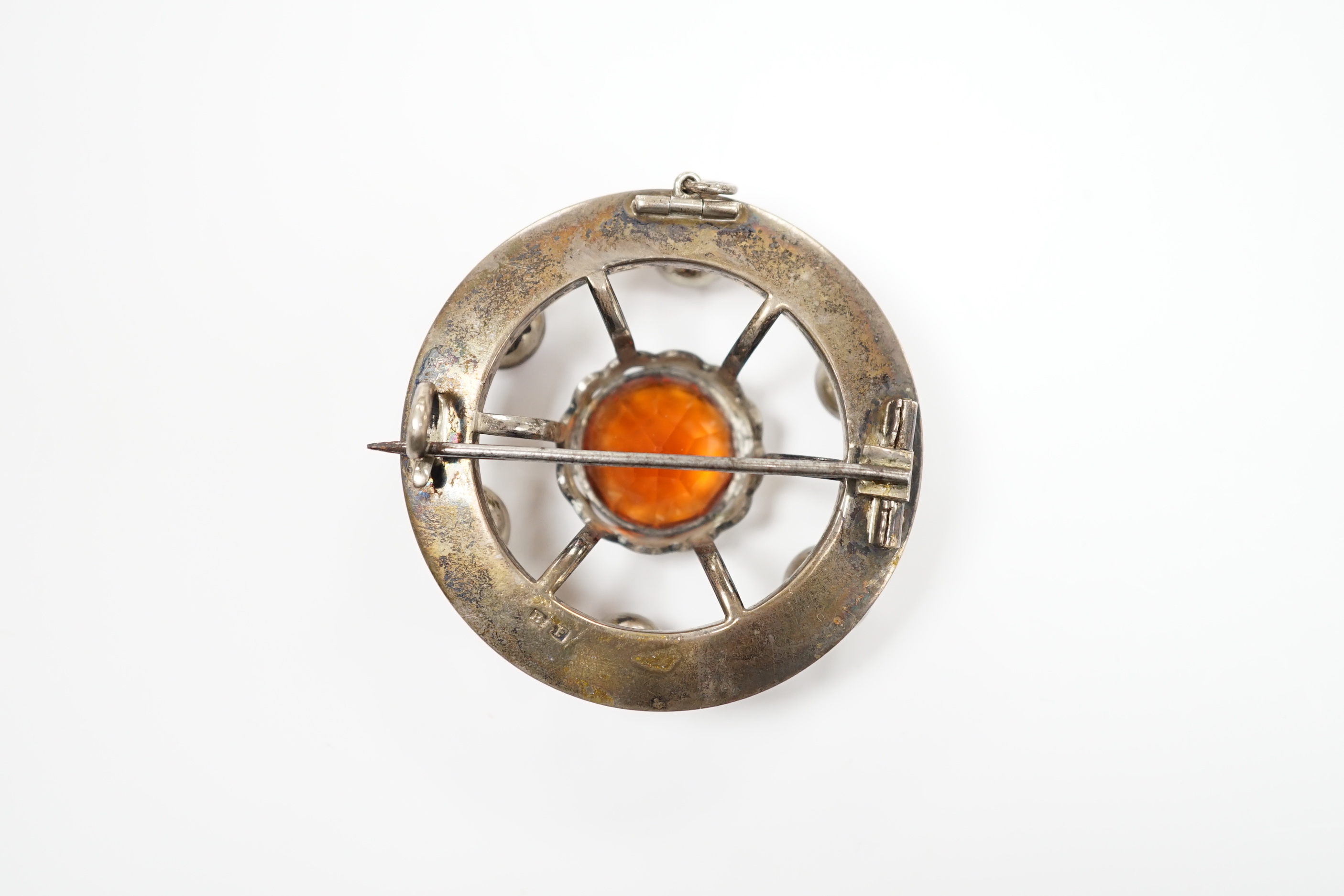 A white metal and multi gem set openwork circular brooch, with central dark citrine, diameter 49mm.